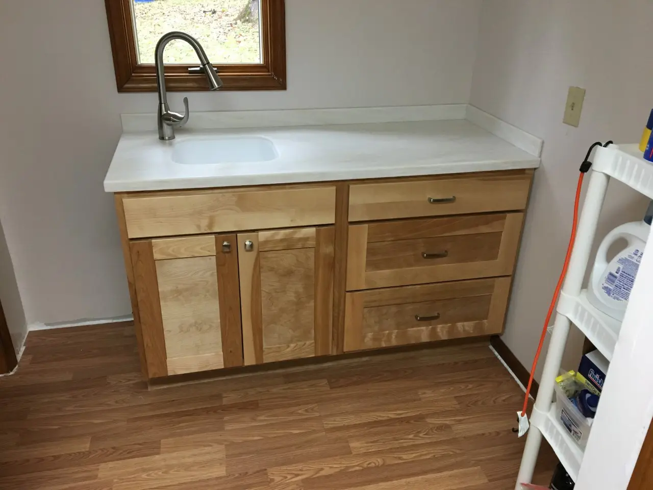 Custom laundry room cabinet with solid surface countertop and integrated sink